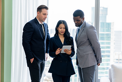 diverse smart businesspeople standing near window with skyscraper. ornamented..